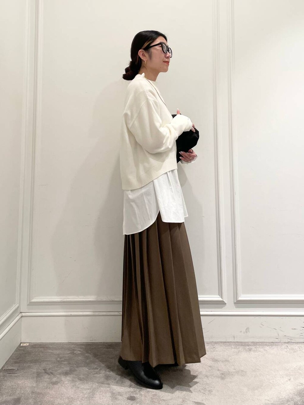 ブラック系のショルダーバッグ、ブラウン系のスカート、ホワイト系のシャツ/ブラウスを着用したレディースの冬コーディネートの4枚目の写真