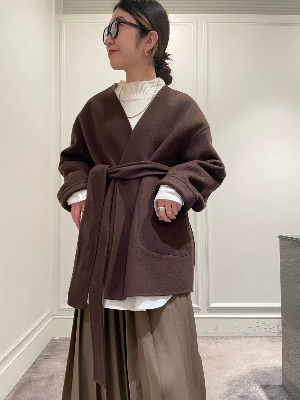 ブラウン系のノーカラージャケット、ブラウン系のスカート、ホワイト系のシャツ/ブラウスを着用したレディースの冬コーディネートの7枚目の写真