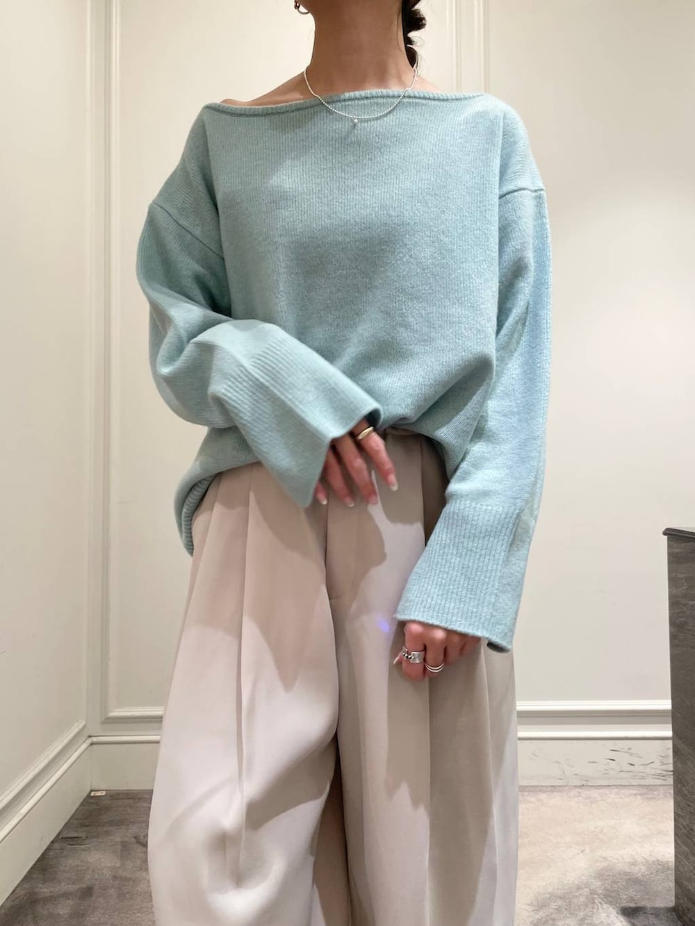 グリーン系のニット/セーター、ベージュ系のその他パンツ、ブラック系のショルダーバッグを着用したレディースの冬コーディネートの8枚目の写真