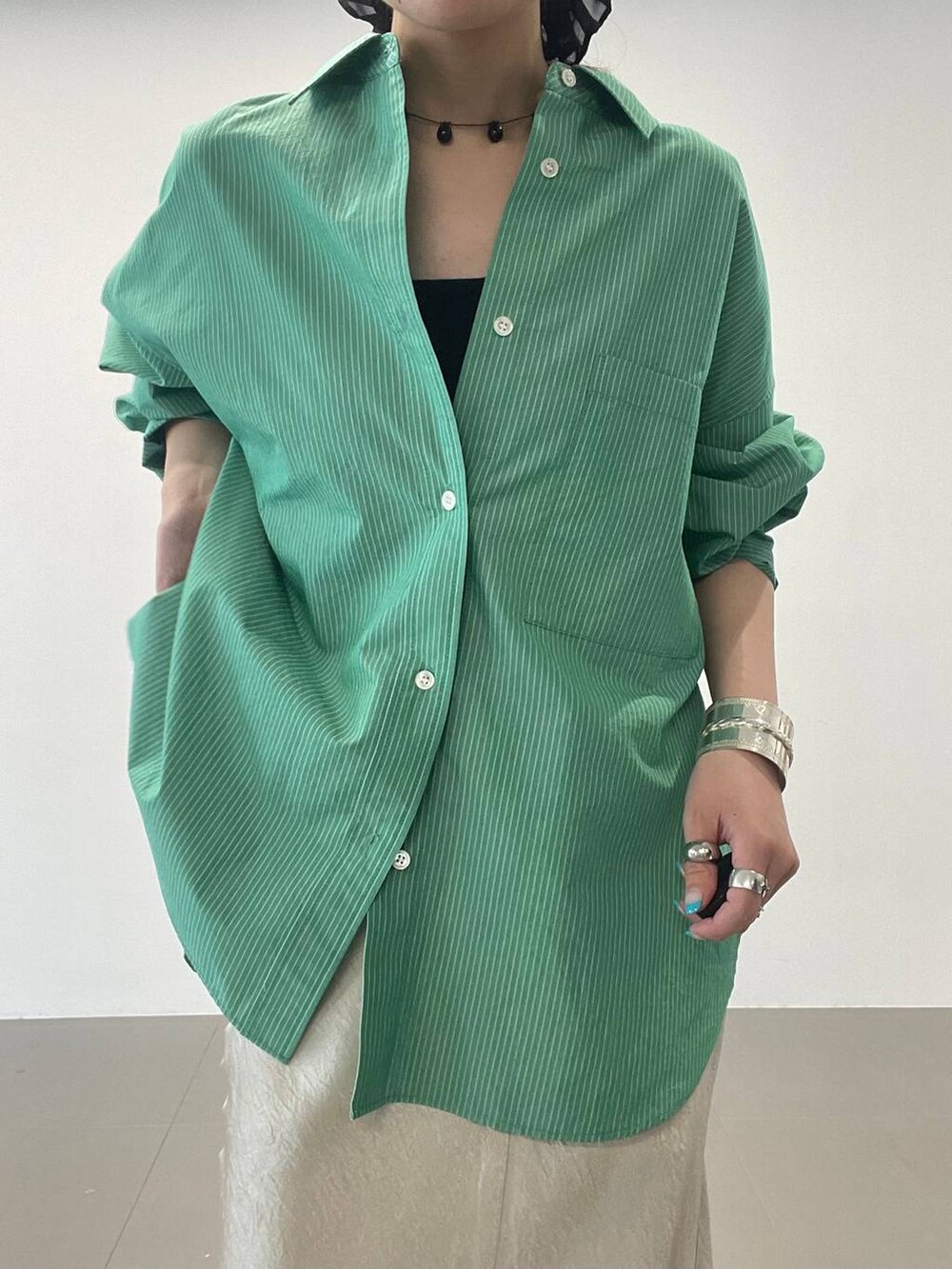 ブラック系のサンダル、ゴールド系のスカート、グリーン系のシャツ/ブラウスを着用したレディースの夏コーディネートの5枚目の写真