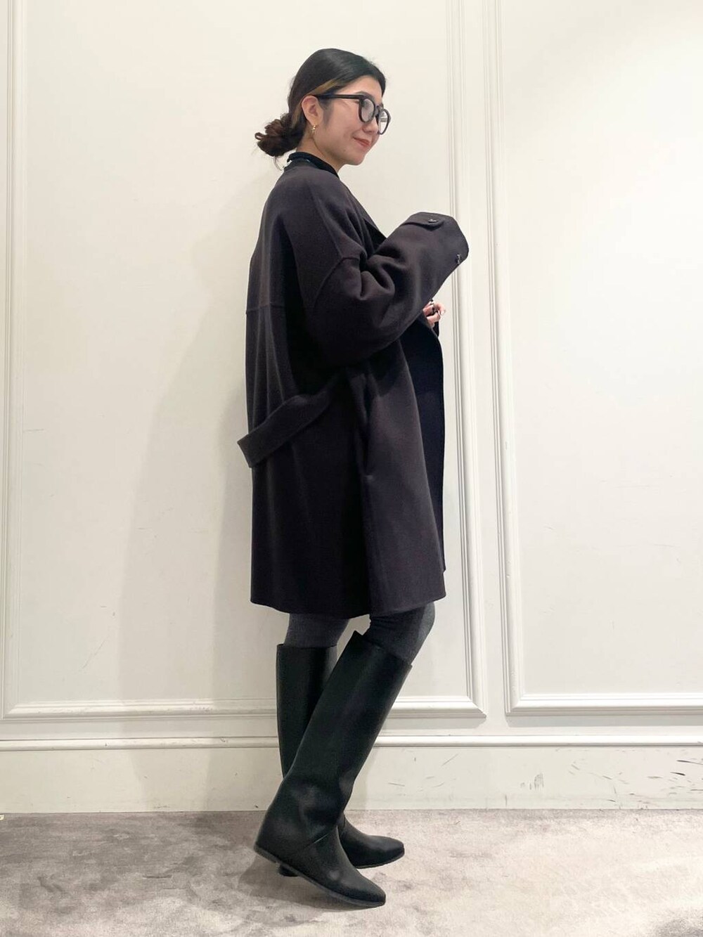 グレー系のピーコート、ブラック系のTシャツ/カットソー、グレー系のニット/セーターを着用したレディースの冬コーディネートの4枚目の写真