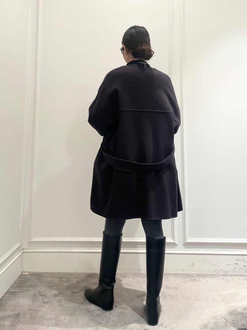 グレー系のピーコート、ブラック系のTシャツ/カットソー、グレー系のニット/セーターを着用したレディースの冬コーディネートの5枚目の写真