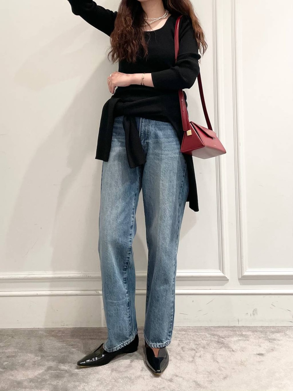ブルー系のデニムパンツ、ブラック系のニット/セーター、ブラック系のニット/セーターを着用したレディースの冬コーディネートの4枚目の写真