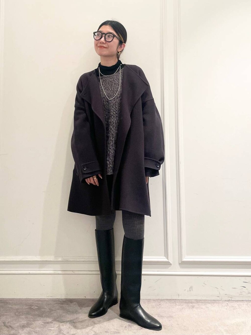 グレー系のピーコート、ブラック系のTシャツ/カットソー、グレー系のニット/セーターを着用したレディースの冬コーディネートの3枚目の写真