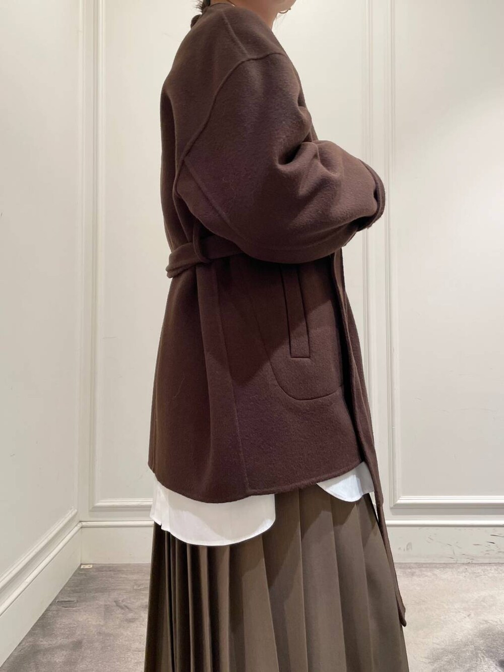 ブラウン系のノーカラージャケット、ブラウン系のスカート、ホワイト系のシャツ/ブラウスを着用したレディースの冬コーディネートの8枚目の写真