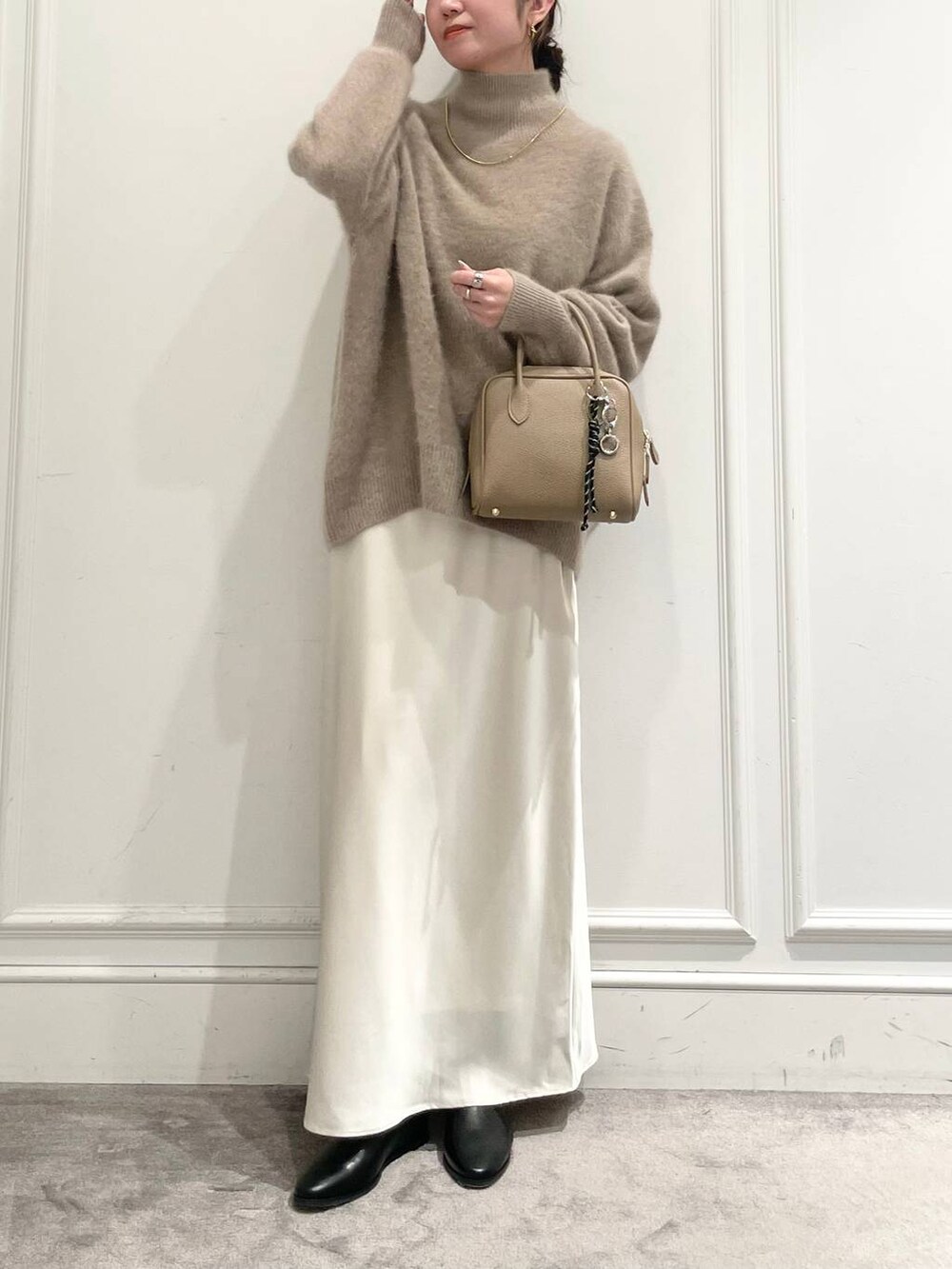 ホワイト系のスカート、ブラウン系のニット/セーターを着用したレディースの冬コーディネートの3枚目の写真