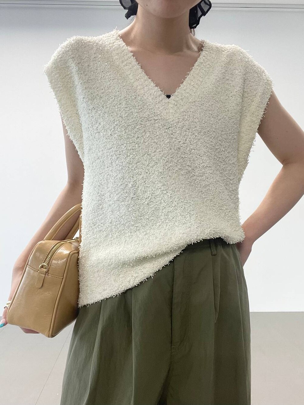 ゴールド系のパンプス、グリーン系のカーゴパンツ、ホワイト系のニット/セーターを着用したレディースの夏コーディネートの5枚目の写真