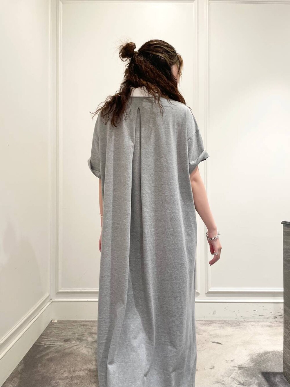 グレー系のワンピース、ブルー系のハンドバッグ、ブラック系のキャミソールを着用したレディースの夏コーディネートの7枚目の写真