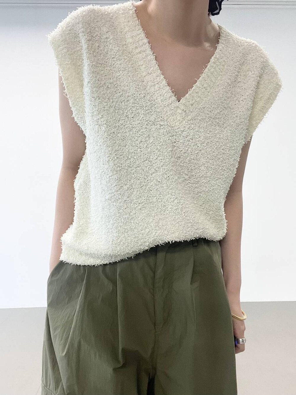 ゴールド系のパンプス、グリーン系のカーゴパンツ、ホワイト系のニット/セーターを着用したレディースの夏コーディネートの6枚目の写真