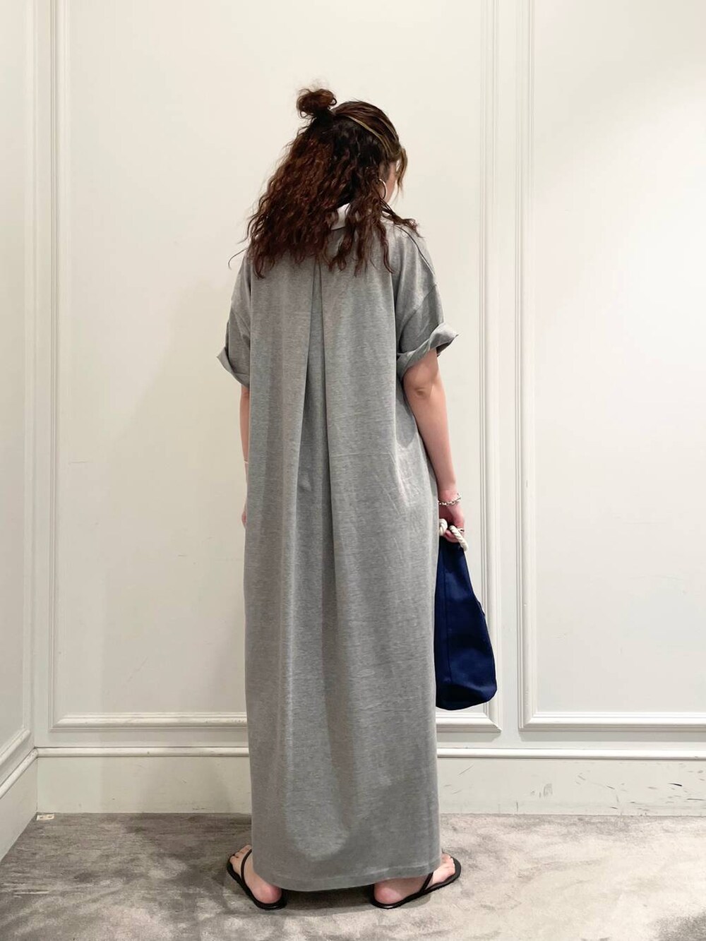 グレー系のワンピース、ブルー系のハンドバッグ、ブラック系のキャミソールを着用したレディースの夏コーディネートの4枚目の写真