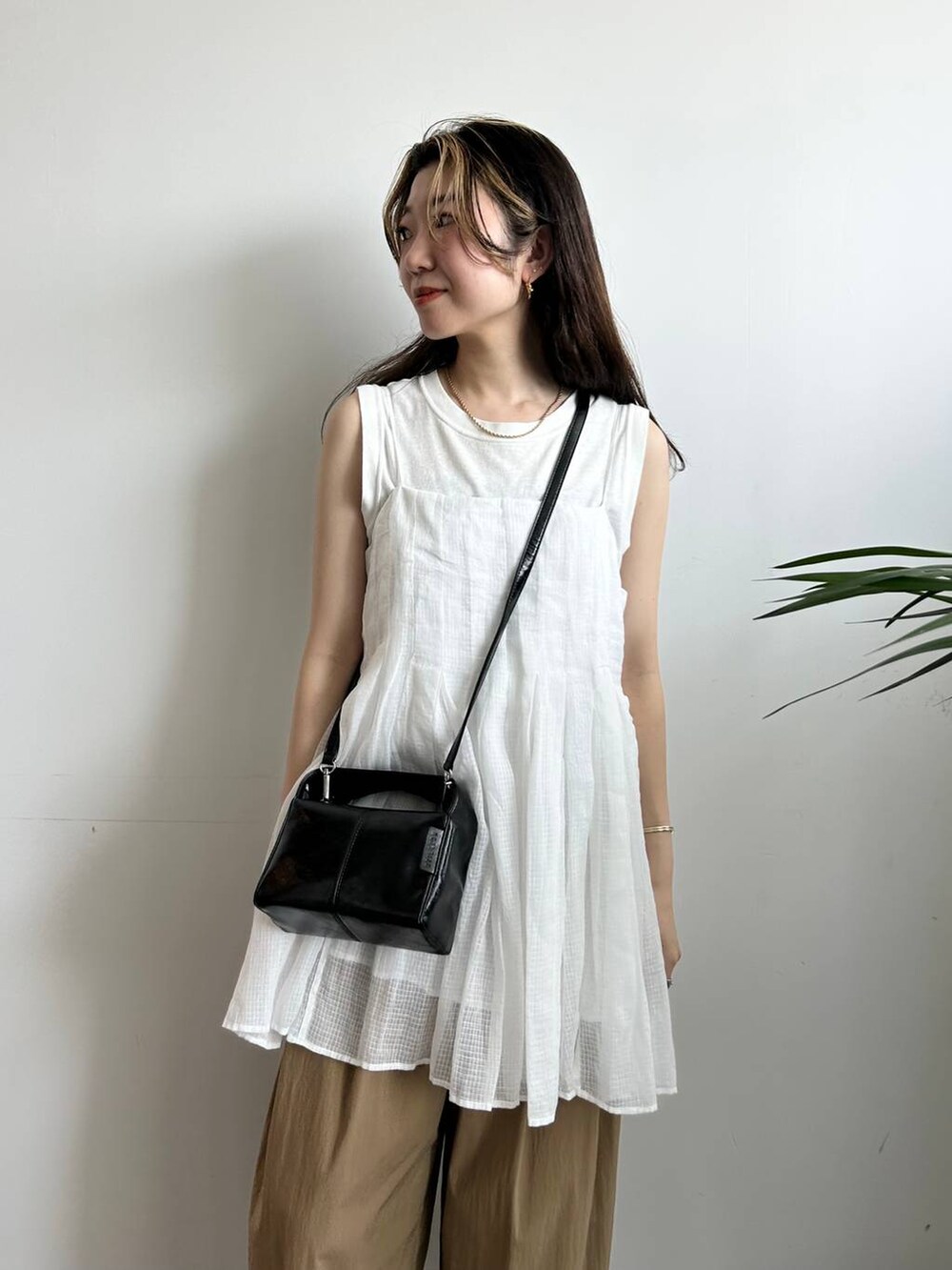 ホワイト系のタンクトップ、ホワイト系のキャミソール、ブラック系のキャミソールを着用したレディースの夏コーディネートの6枚目の写真