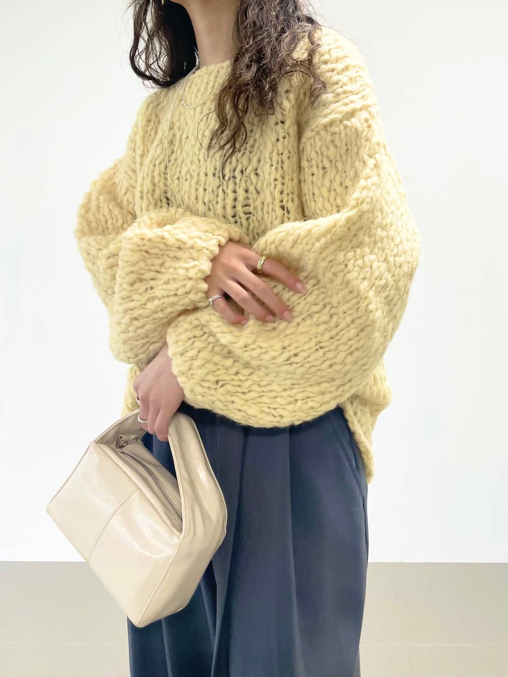 ホワイト系のハンドバッグ、ブラック系のキャミソール、グレー系のその他パンツを着用したレディースの秋コーディネートの7枚目の写真