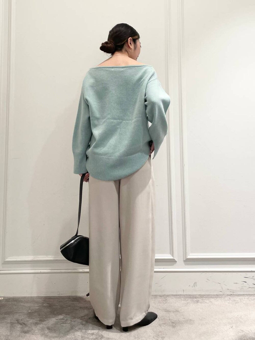 グリーン系のニット/セーター、ベージュ系のその他パンツ、ブラック系のショルダーバッグを着用したレディースの冬コーディネートの5枚目の写真
