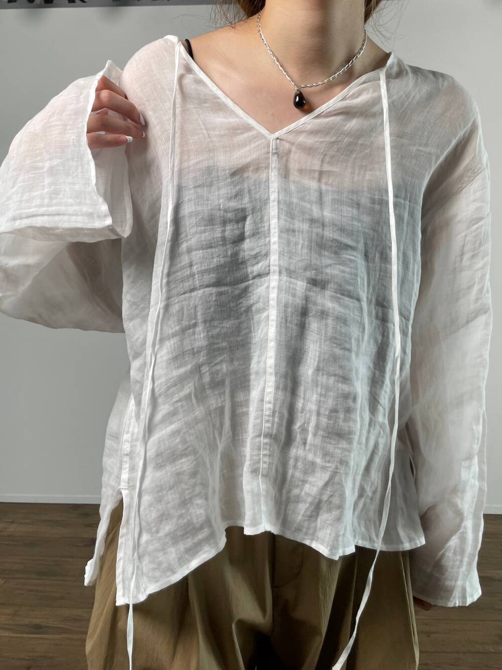 ホワイト系のシャツ/ブラウス、ブラック系のキャミソール、ベージュ系のサンダルを着用したレディースの春コーディネートの7枚目の写真