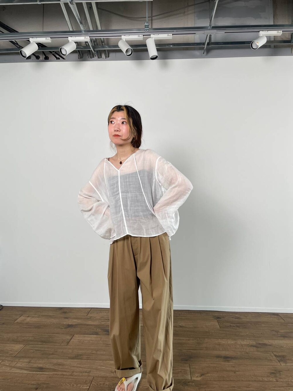 ホワイト系のシャツ/ブラウス、ブラック系のキャミソール、ベージュ系のサンダルを着用したレディースの春コーディネートの6枚目の写真