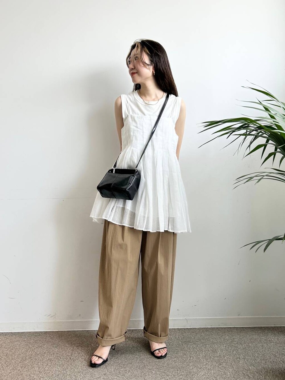 ホワイト系のタンクトップ、ホワイト系のキャミソール、ブラック系のキャミソールを着用したレディースの夏コーディネートの2枚目の写真