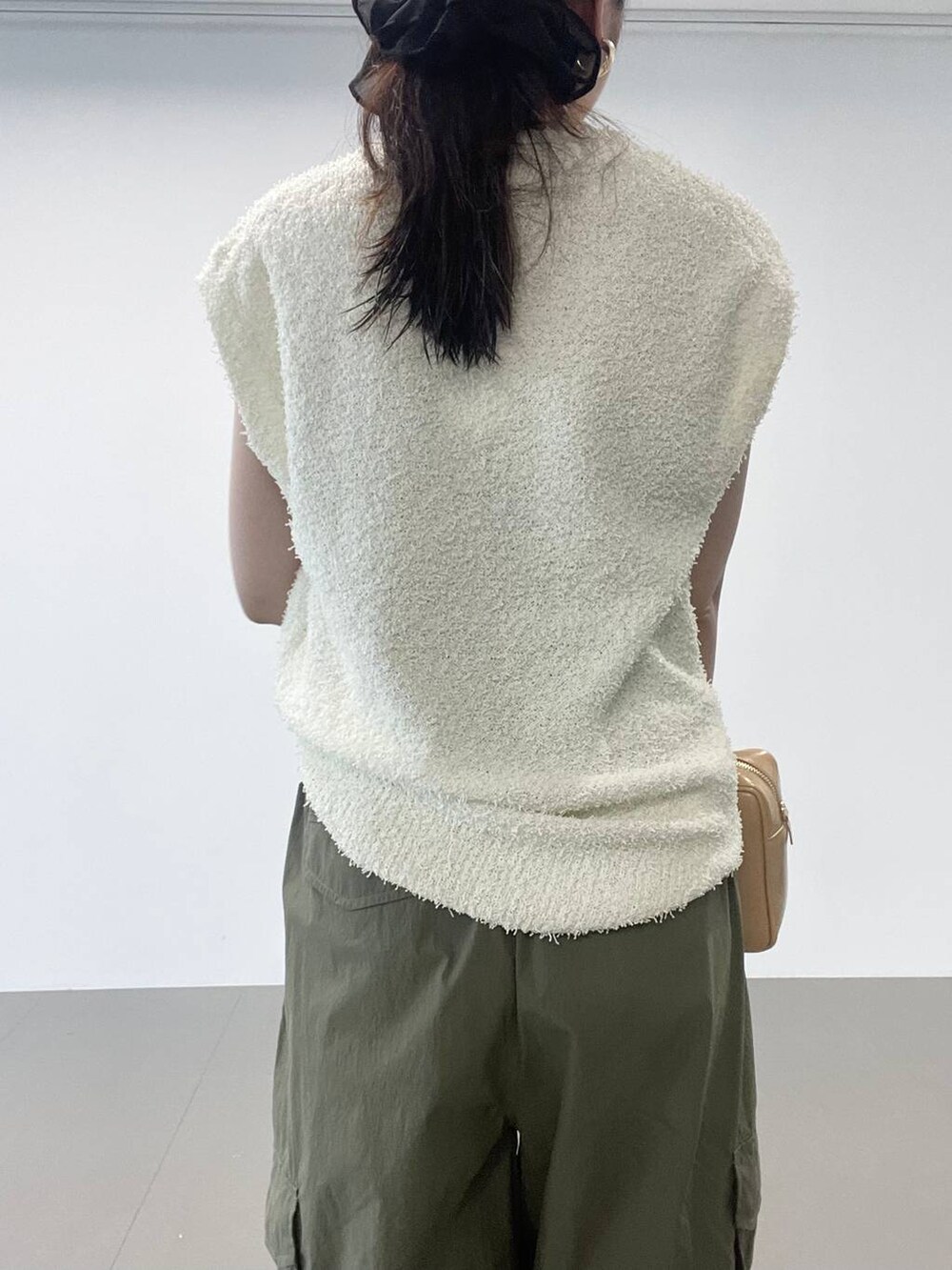 ゴールド系のパンプス、グリーン系のカーゴパンツ、ホワイト系のニット/セーターを着用したレディースの夏コーディネートの9枚目の写真