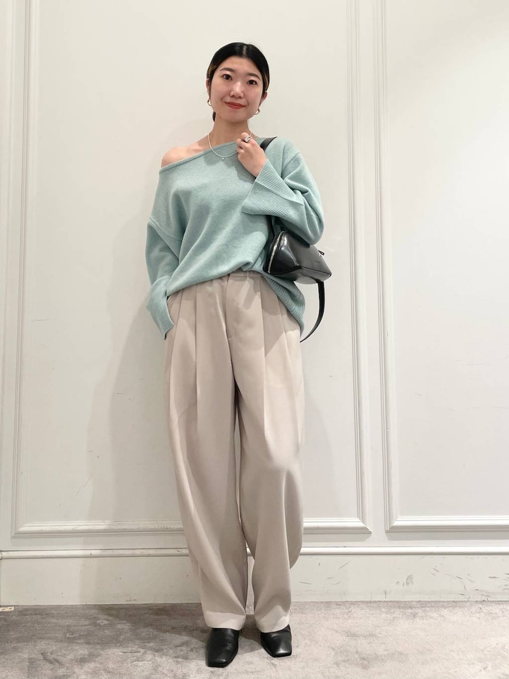 グリーン系のニット/セーター、ベージュ系のその他パンツ、ブラック系のショルダーバッグを着用したレディースの冬コーディネートの3枚目の写真