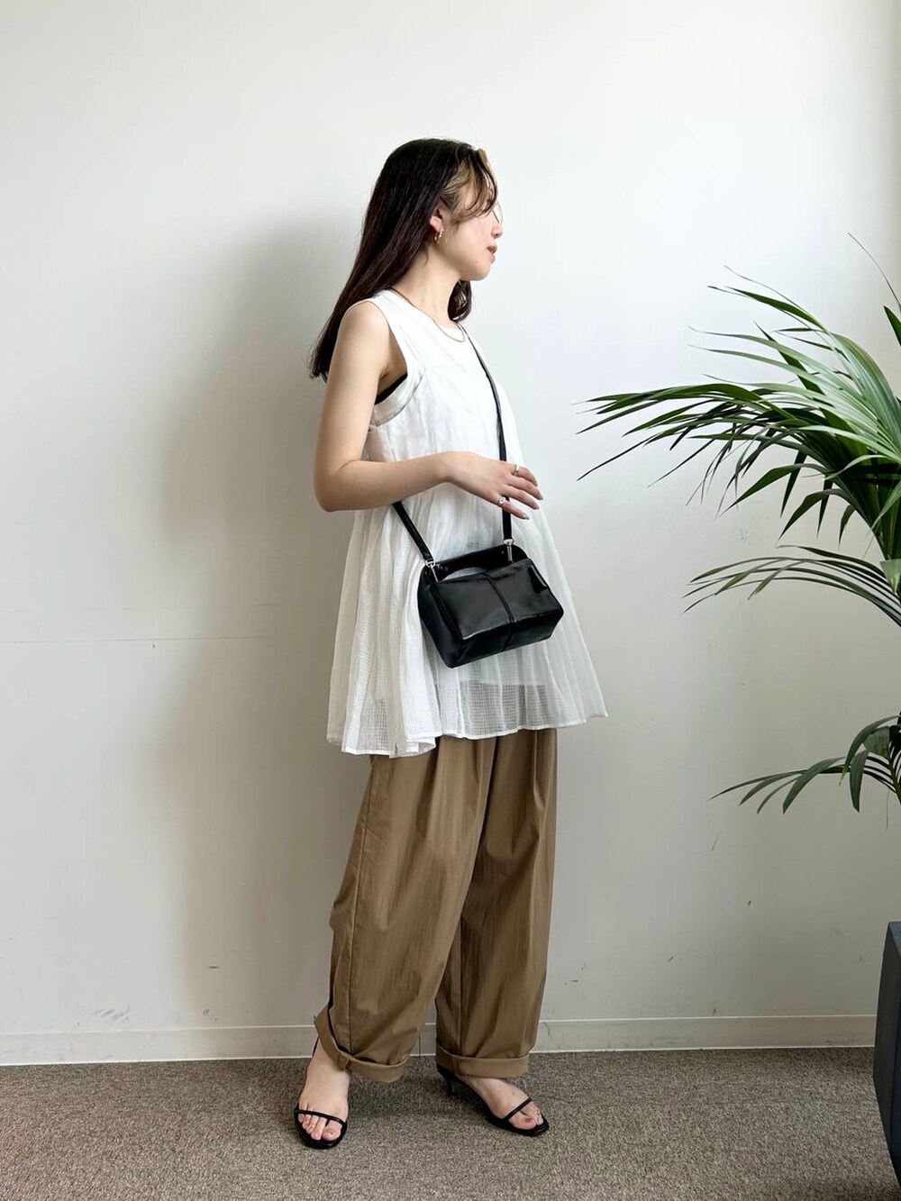 ホワイト系のタンクトップ、ホワイト系のキャミソール、ブラック系のキャミソールを着用したレディースの夏コーディネートの3枚目の写真