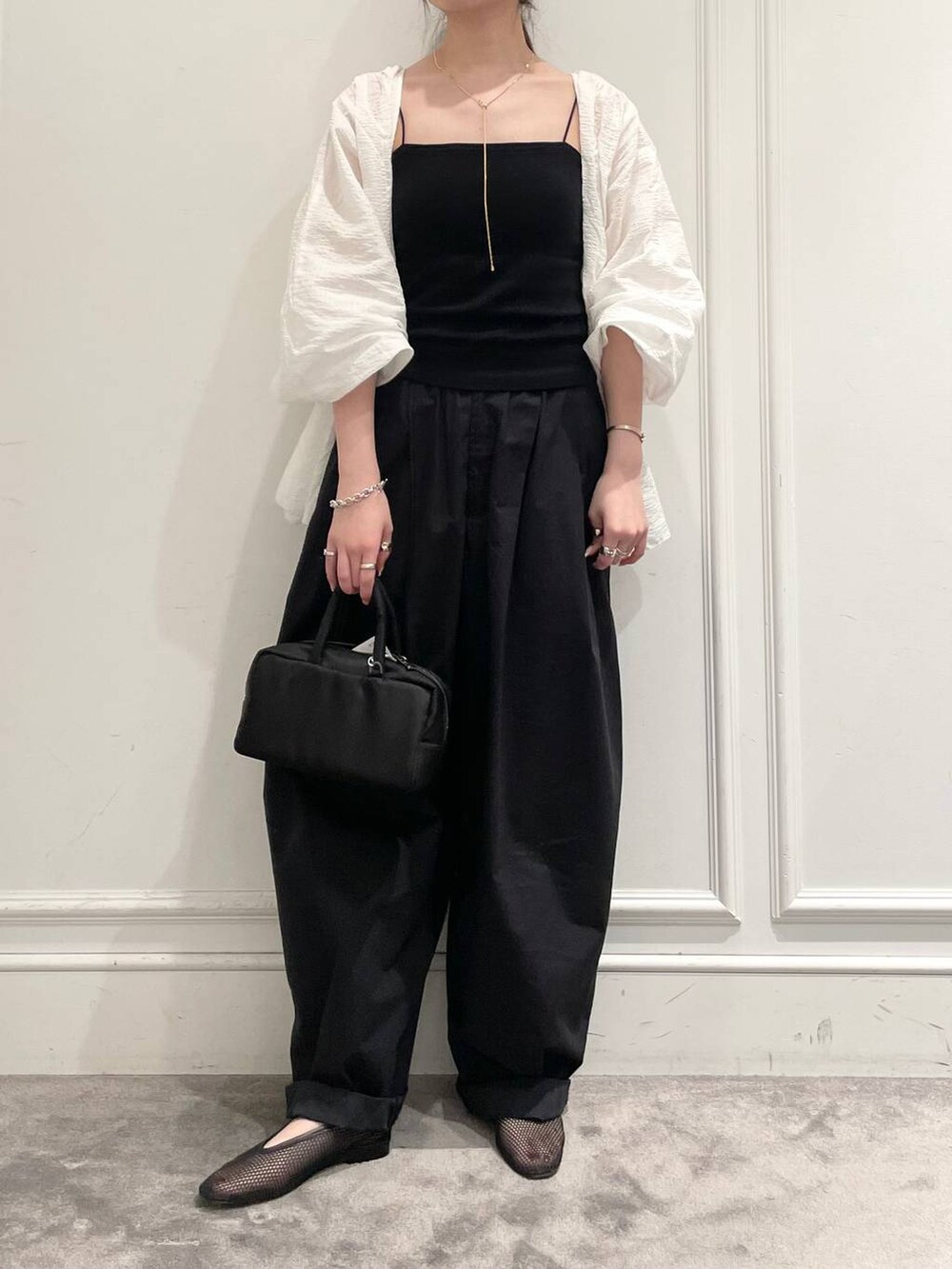 ブラック系のショルダーバッグ、ブラック系のパンプス、ブラック系のキャミソールを着用したレディースの夏コーディネートの2枚目の写真