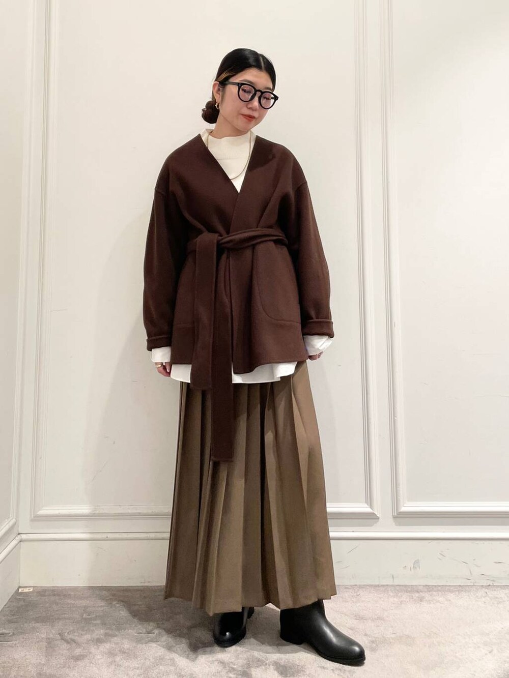 ブラウン系のノーカラージャケット、ブラウン系のスカート、ホワイト系のシャツ/ブラウスを着用したレディースの冬コーディネートの2枚目の写真