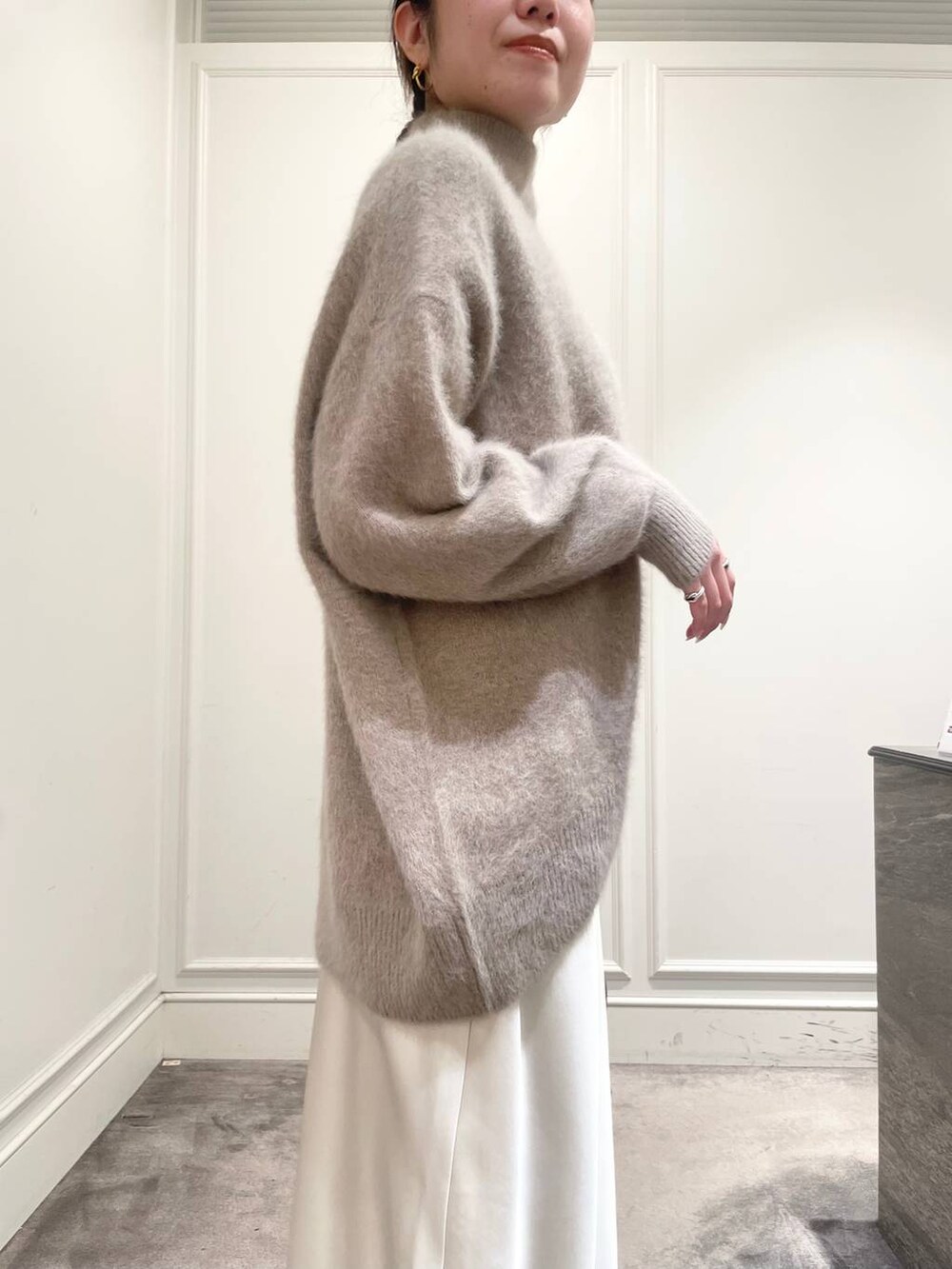 ホワイト系のスカート、ブラウン系のニット/セーターを着用したレディースの冬コーディネートの8枚目の写真