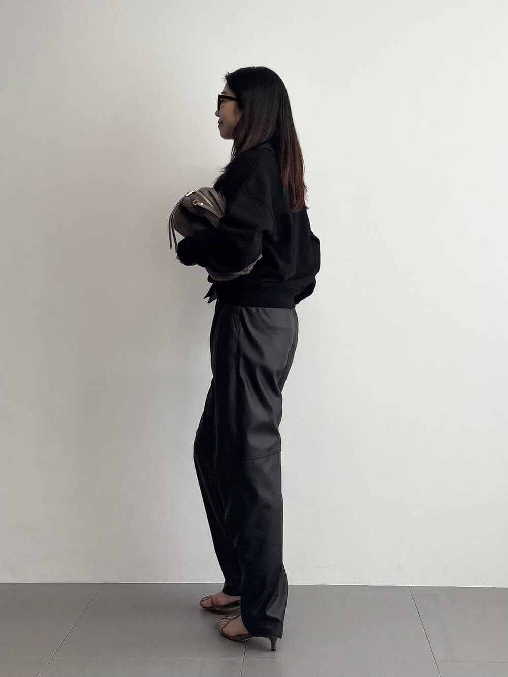 ベージュ系のサンダル、ベージュ系のハンドバッグ、ブラック系のその他パンツを着用したレディースの秋コーディネートの4枚目の写真