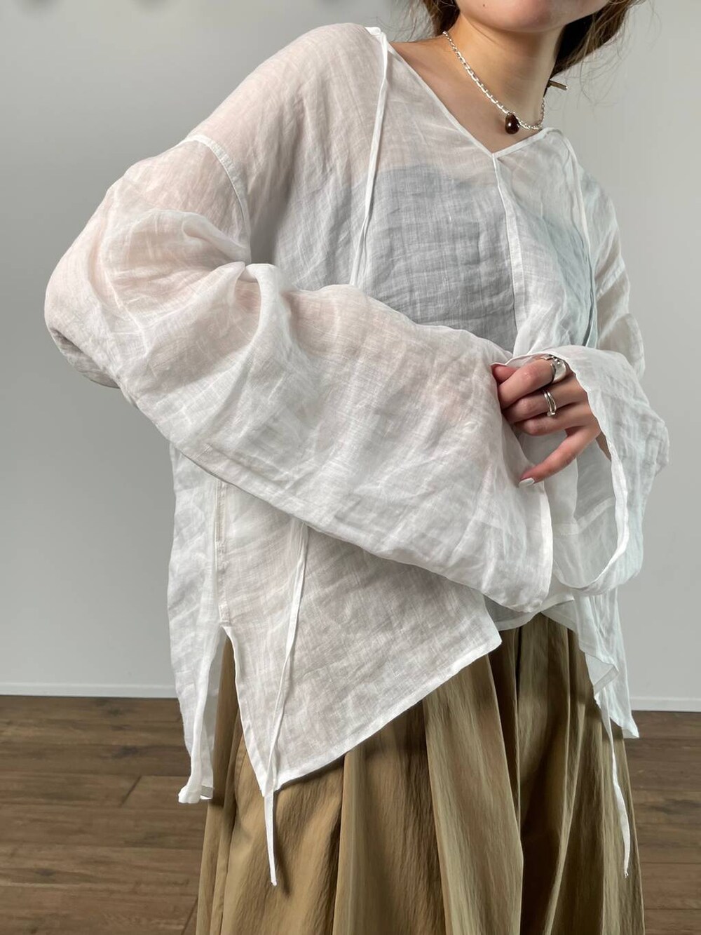 ホワイト系のシャツ/ブラウス、ブラック系のキャミソール、ベージュ系のサンダルを着用したレディースの春コーディネートの8枚目の写真