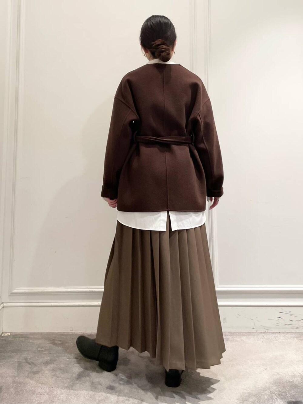 ブラウン系のノーカラージャケット、ブラウン系のスカート、ホワイト系のシャツ/ブラウスを着用したレディースの冬コーディネートの6枚目の写真