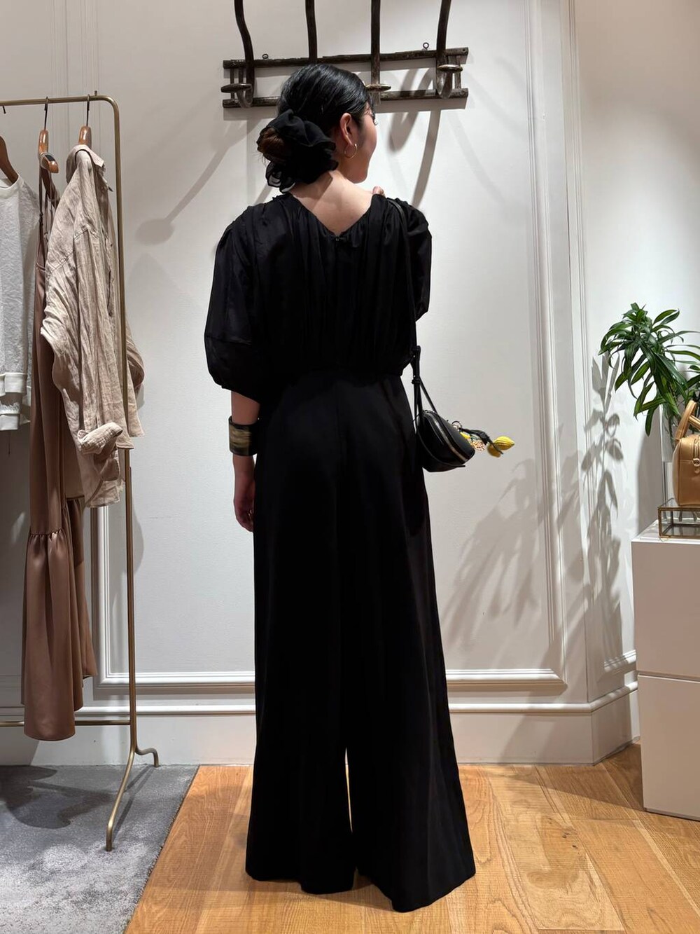 ブラック系のサンダル、ブラック系のつなぎ/オールインワン、ブラック系のショルダーバッグを着用したレディースの夏コーディネートの5枚目の写真