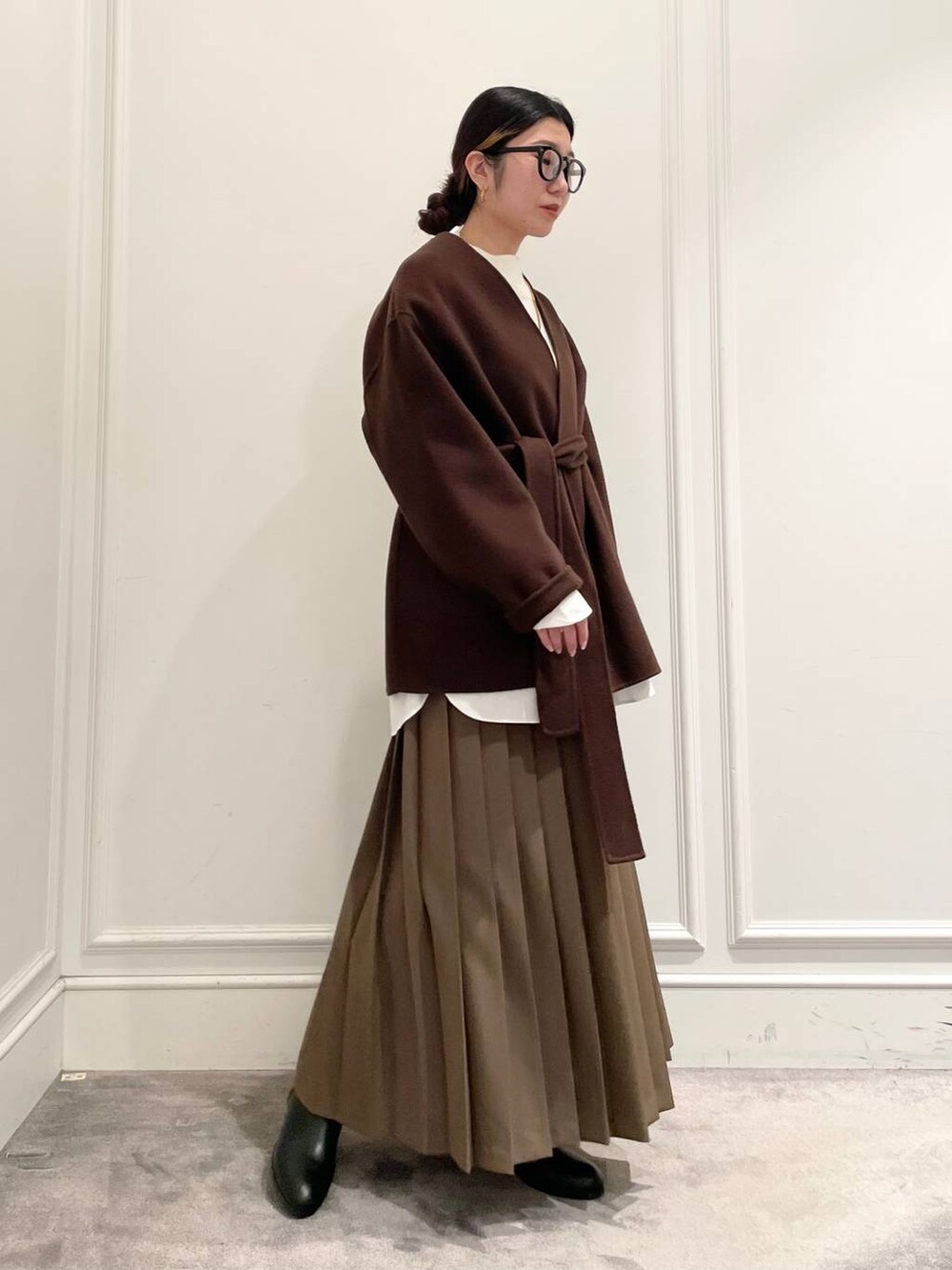 ブラウン系のノーカラージャケット、ブラウン系のスカート、ホワイト系のシャツ/ブラウスを着用したレディースの冬コーディネートの4枚目の写真