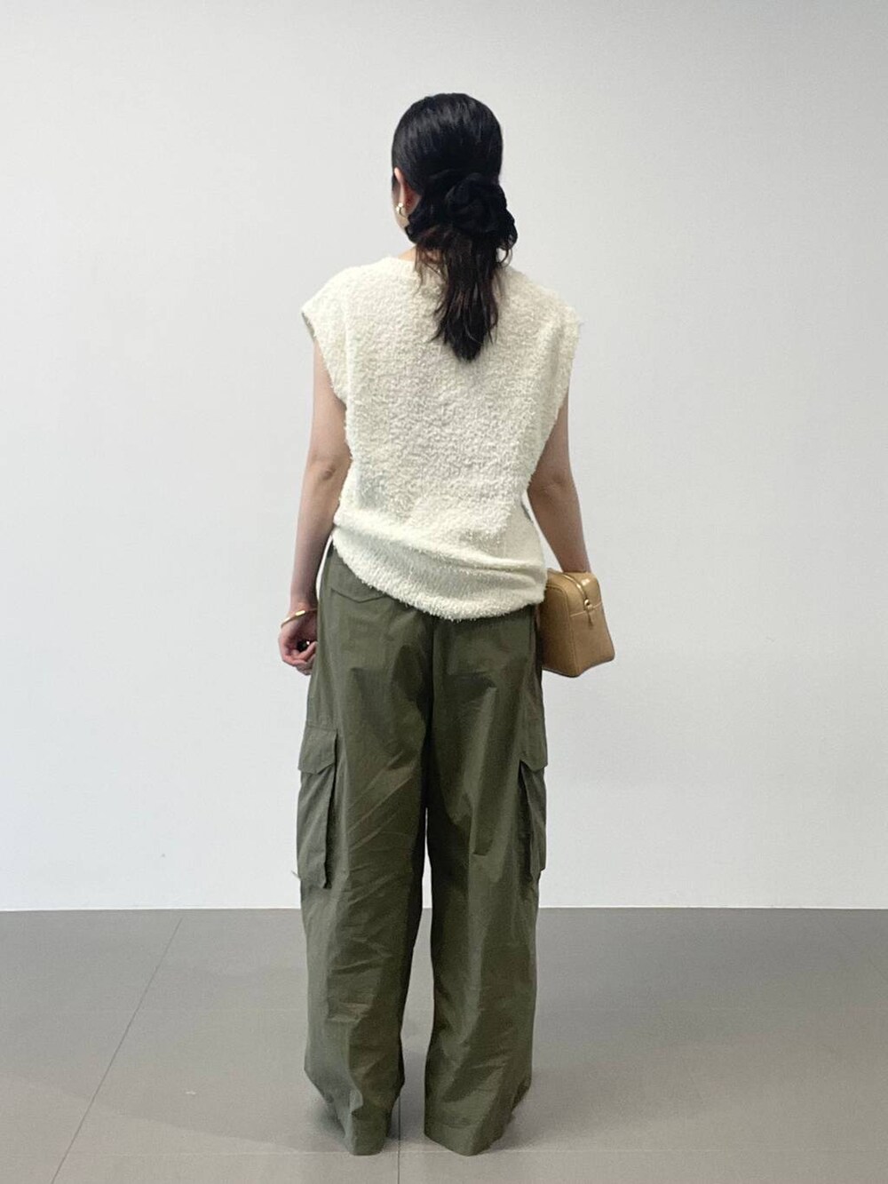 ゴールド系のパンプス、グリーン系のカーゴパンツ、ホワイト系のニット/セーターを着用したレディースの夏コーディネートの4枚目の写真