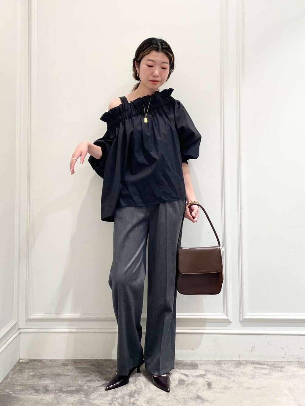 グレー系のその他パンツ、ブラック系のシャツ/ブラウス、ブラウン系のブレスレットを着用したレディースの秋コーディネートの2枚目の写真