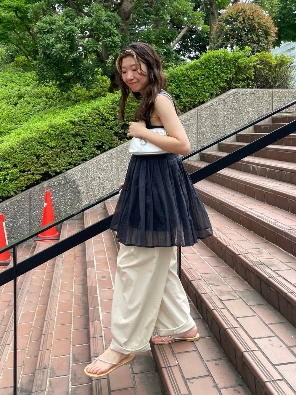 グレー系のタンクトップ、ブラック系のキャミソール、ホワイト系のその他パンツを着用したレディースの夏コーディネートの6枚目の写真