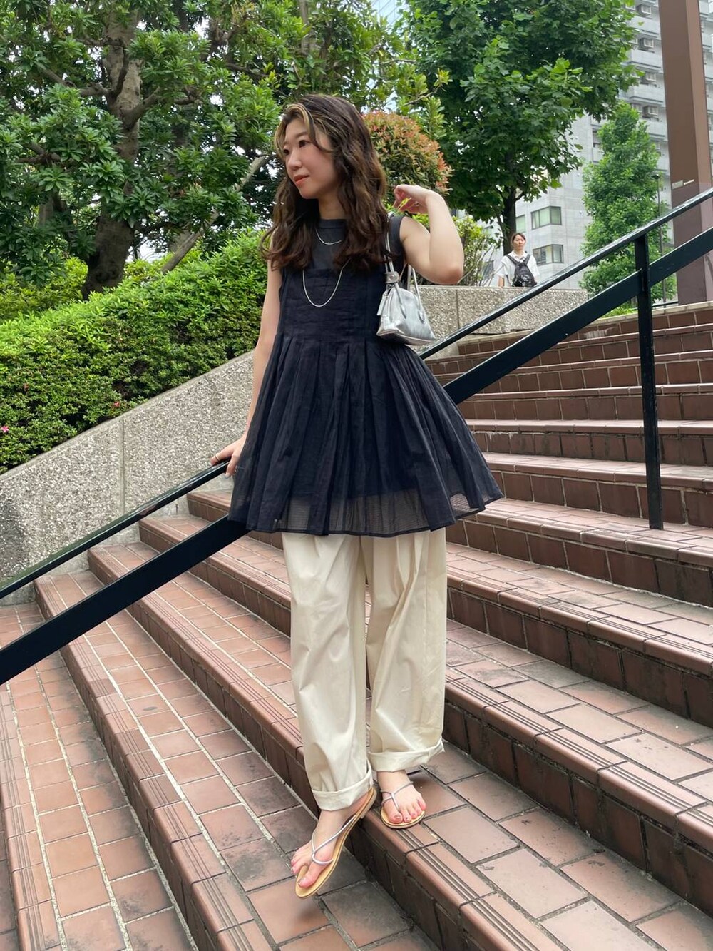 グレー系のタンクトップ、ブラック系のキャミソール、ホワイト系のその他パンツを着用したレディースの夏コーディネートの4枚目の写真