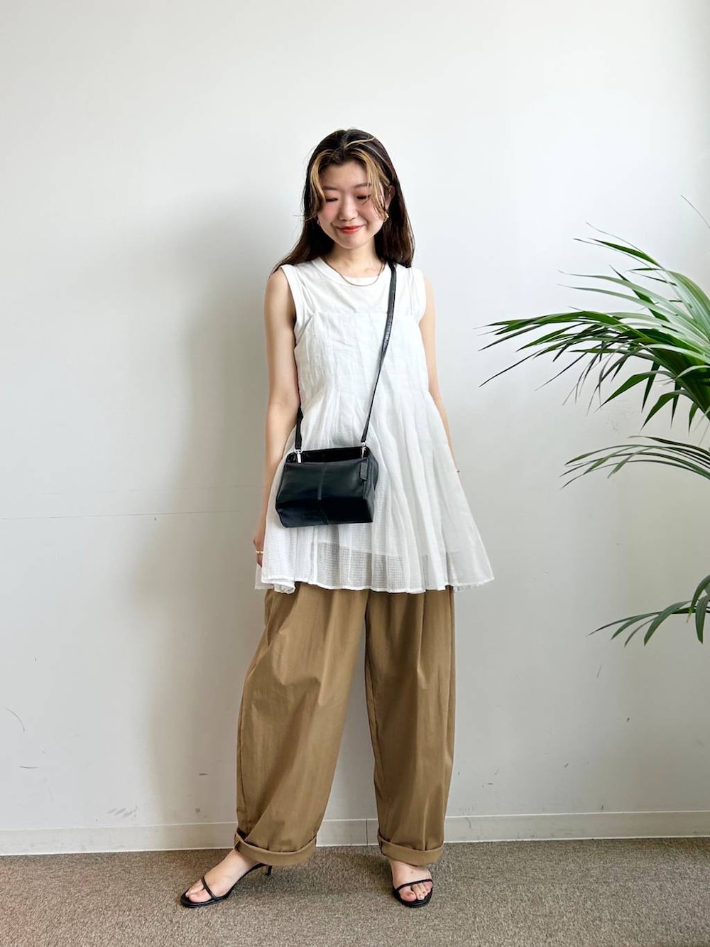 ホワイト系のタンクトップ、ホワイト系のキャミソール、ブラック系のキャミソールを着用したレディースの夏コーディネートの4枚目の写真