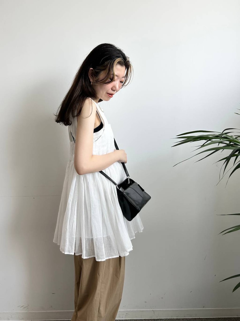ホワイト系のタンクトップ、ホワイト系のキャミソール、ブラック系のキャミソールを着用したレディースの夏コーディネートの7枚目の写真