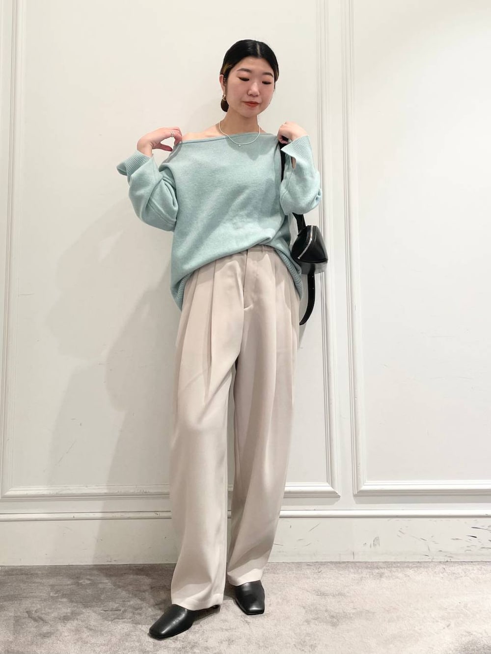 グリーン系のニット/セーター、ベージュ系のその他パンツ、ブラック系のショルダーバッグを着用したレディースの冬コーディネートの2枚目の写真