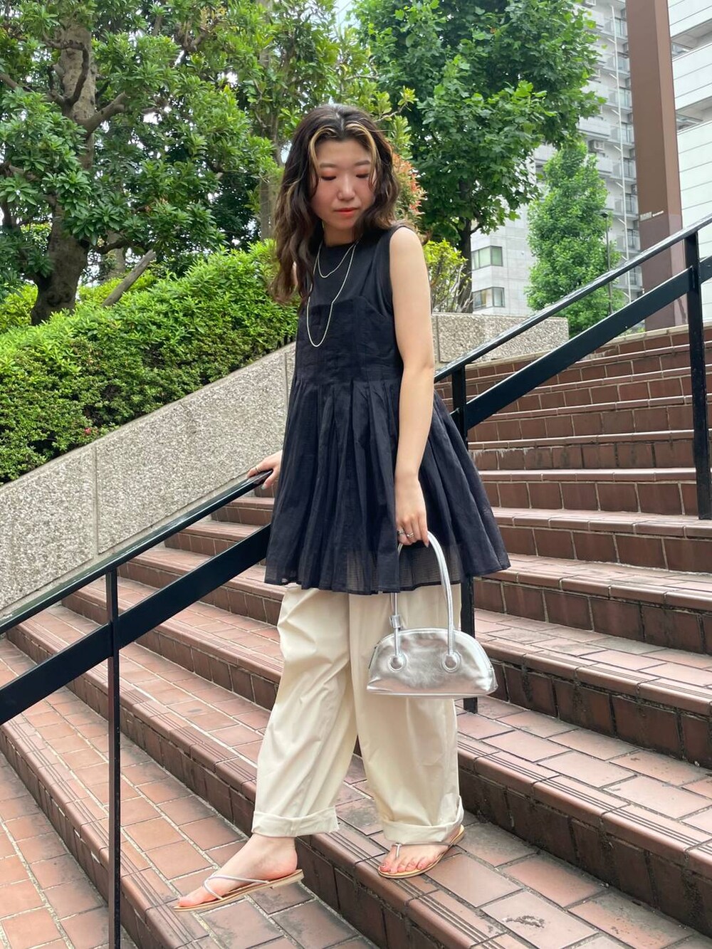 グレー系のタンクトップ、ブラック系のキャミソール、ホワイト系のその他パンツを着用したレディースの夏コーディネートの5枚目の写真