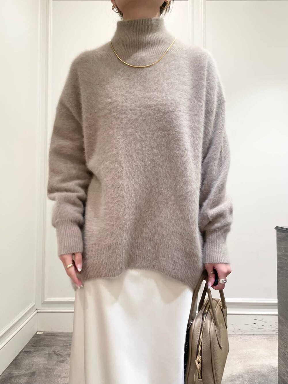 ホワイト系のスカート、ブラウン系のニット/セーターを着用したレディースの冬コーディネートの7枚目の写真