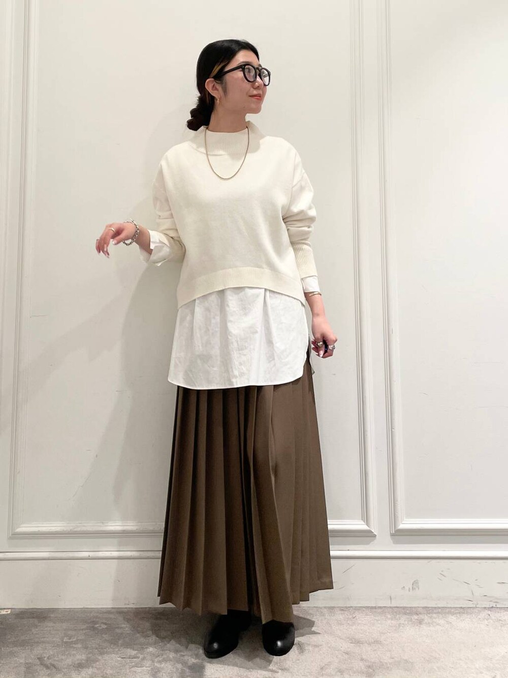 ブラック系のショルダーバッグ、ブラウン系のスカート、ホワイト系のシャツ/ブラウスを着用したレディースの冬コーディネートの3枚目の写真