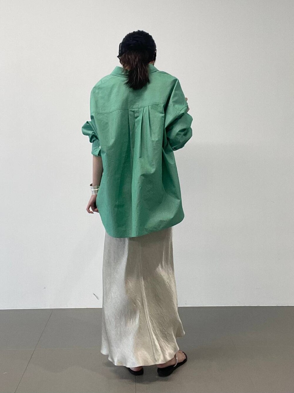 ブラック系のサンダル、ゴールド系のスカート、グリーン系のシャツ/ブラウスを着用したレディースの夏コーディネートの4枚目の写真