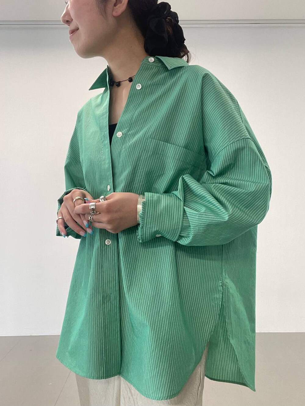 ブラック系のサンダル、ゴールド系のスカート、グリーン系のシャツ/ブラウスを着用したレディースの夏コーディネートの6枚目の写真