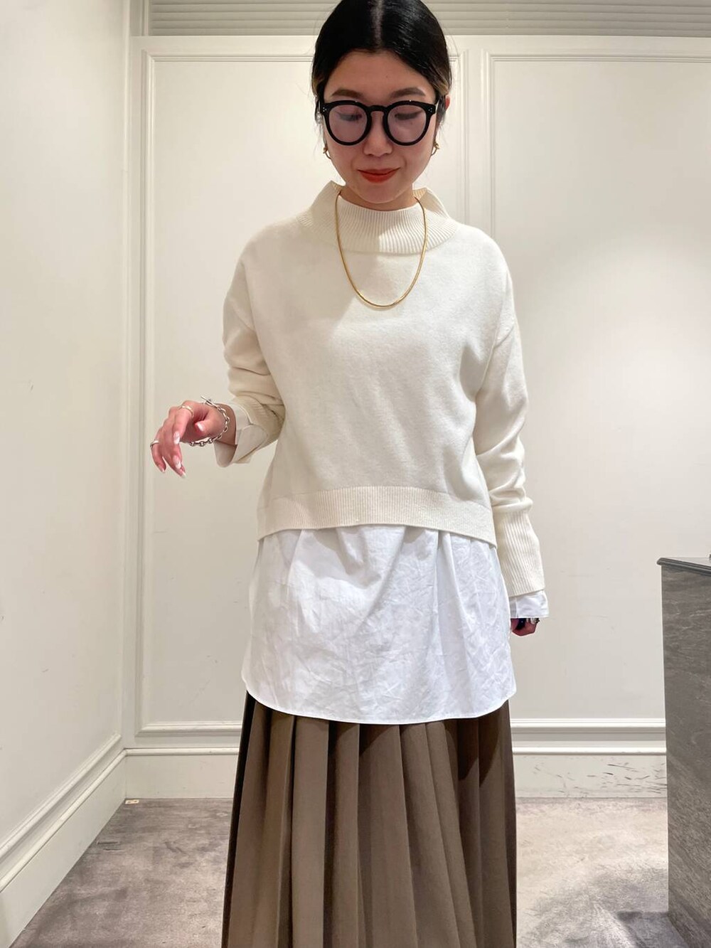 ブラック系のショルダーバッグ、ブラウン系のスカート、ホワイト系のシャツ/ブラウスを着用したレディースの冬コーディネートの7枚目の写真