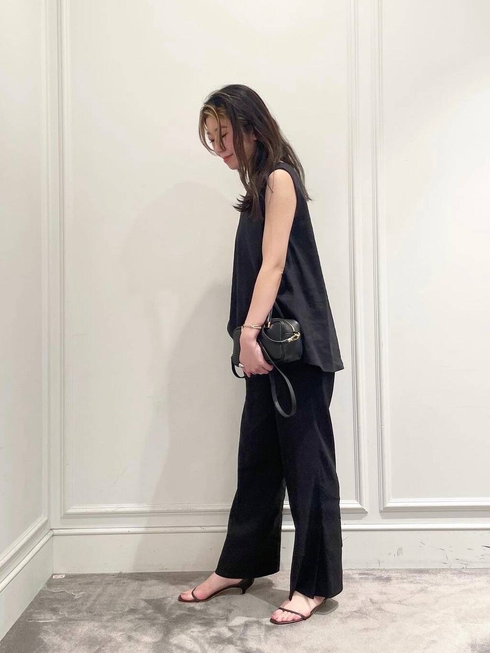 ブラック系のショルダーバッグ、ブラウン系のサンダル、グレー系のシャツ/ブラウスを着用したレディースの夏コーディネートの3枚目の写真