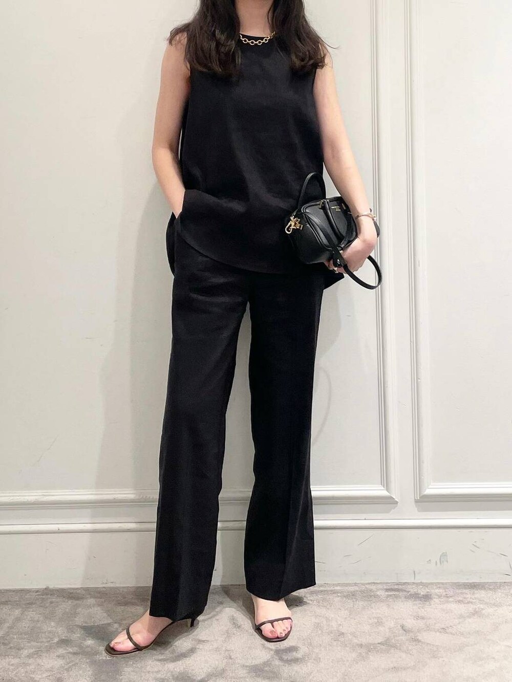 ブラック系のショルダーバッグ、ブラウン系のサンダル、グレー系のシャツ/ブラウスを着用したレディースの夏コーディネートの6枚目の写真