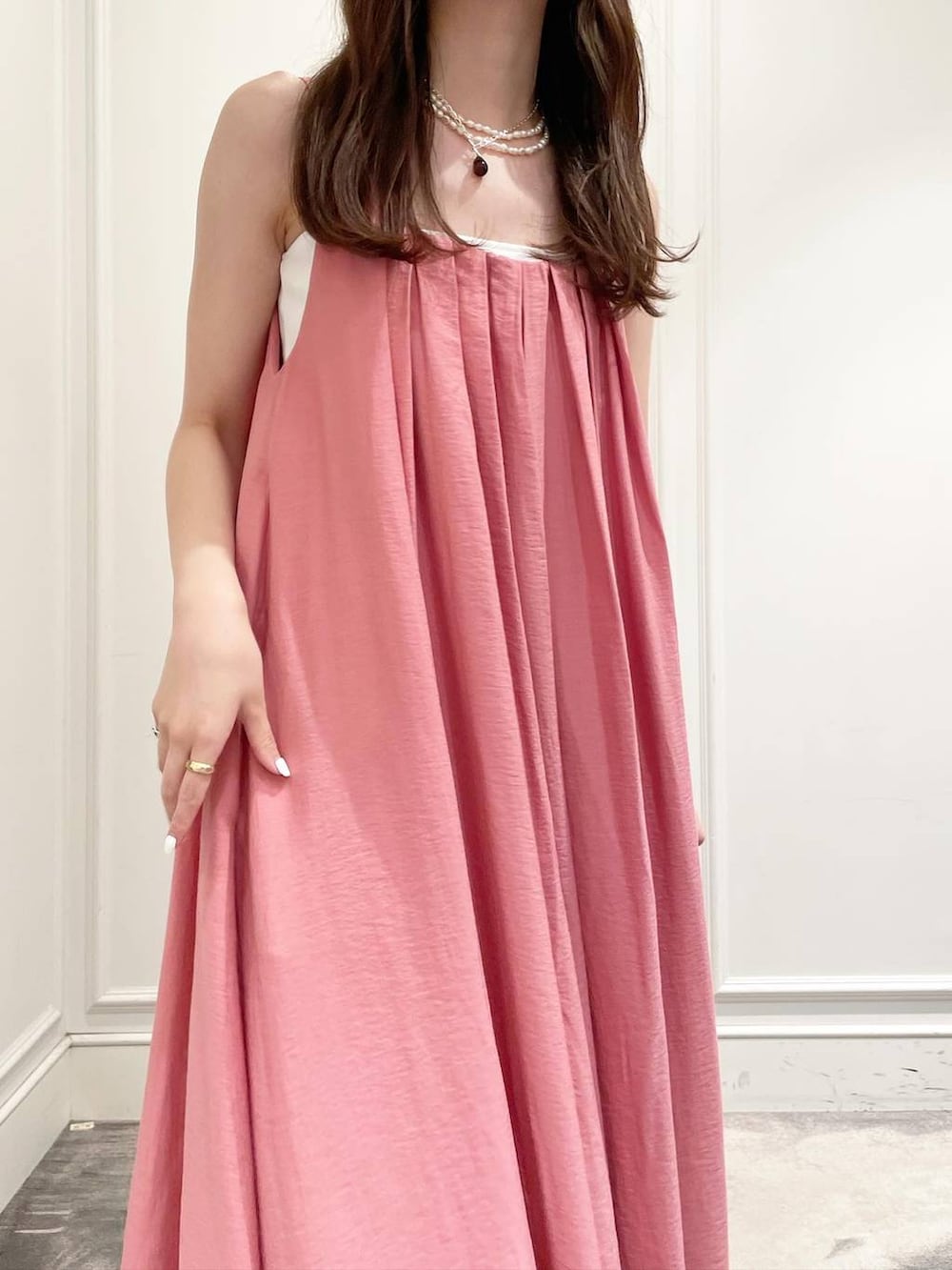 ホワイト系のキャミソール、ピンク系のワンピース、イエロー系のサンダルを着用したレディースの夏コーディネートの6枚目の写真