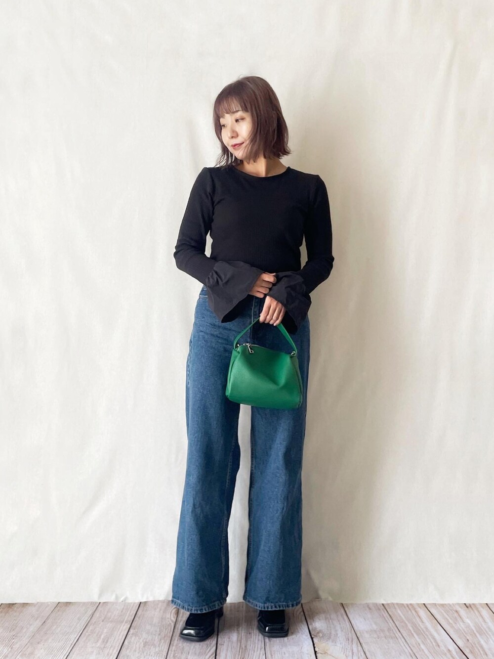 ブラック系のTシャツ/カットソー、グリーン系のショルダーバッグ、ブルー系のその他パンツを着用したレディースの秋コーディネートの2枚目の写真