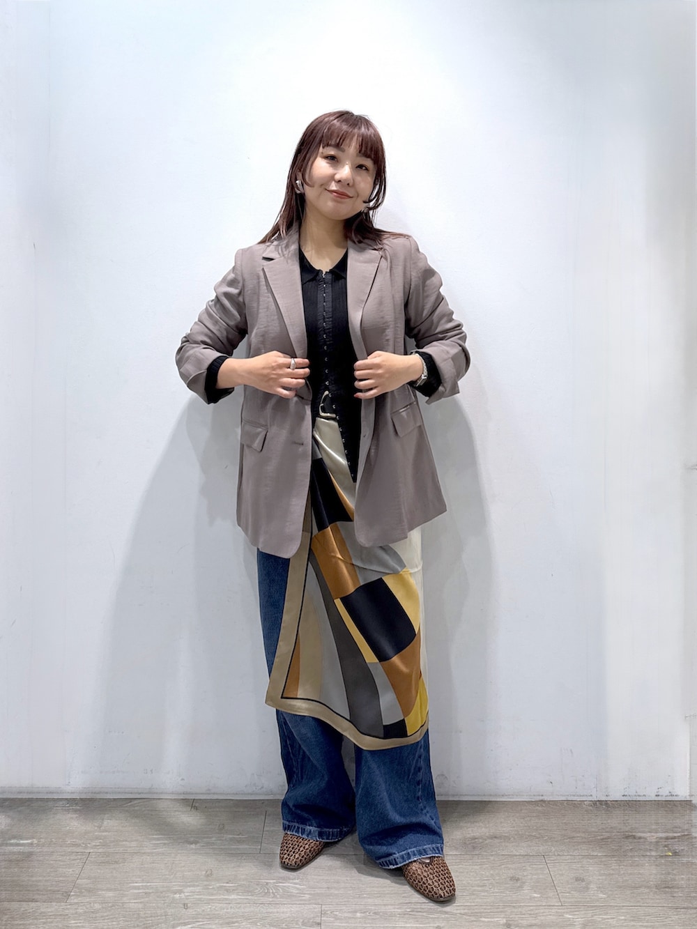 ブラック系のカーディガン/ボレロ、ブラウン系のテーラードジャケット、ブルー系のデニムパンツを着用したレディースの春コーディネートの3枚目の写真