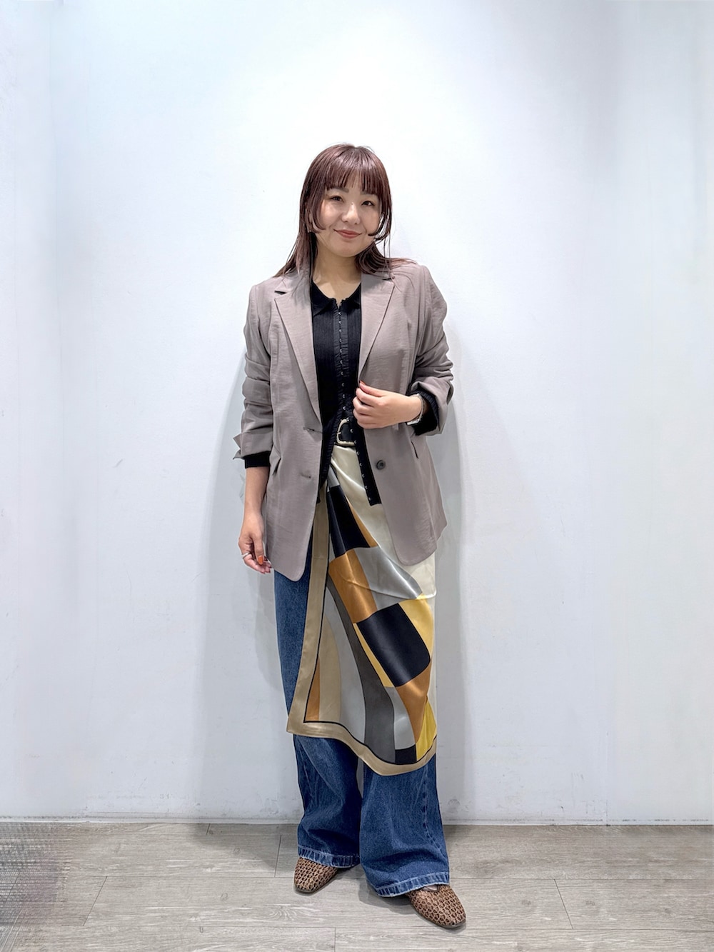 ブラック系のカーディガン/ボレロ、ブラウン系のテーラードジャケット、ブルー系のデニムパンツを着用したレディースの春コーディネートの2枚目の写真